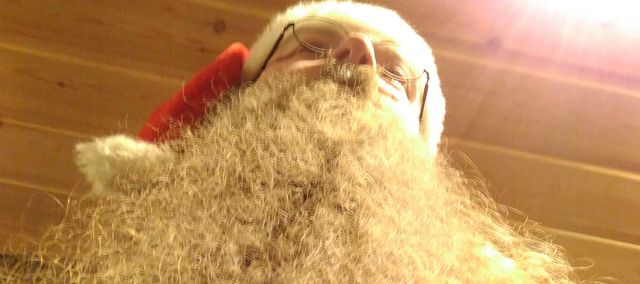 Utsikt nedenfra til en person med stort hvitt skjegg og nisselue.